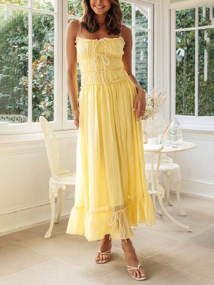 Stylish yellow spaghetti strap midi dress, a flattering boho design for casual or elegant summer wear.