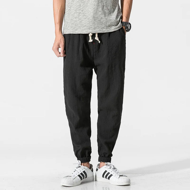 Men's tapered joggers in grey, elastic waist & drawstring, suitable for active wear, loungewear & comfort.