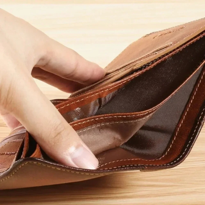 Hand holding a compact men's vintage genuine leather wallet, an essential classic everyday carry.