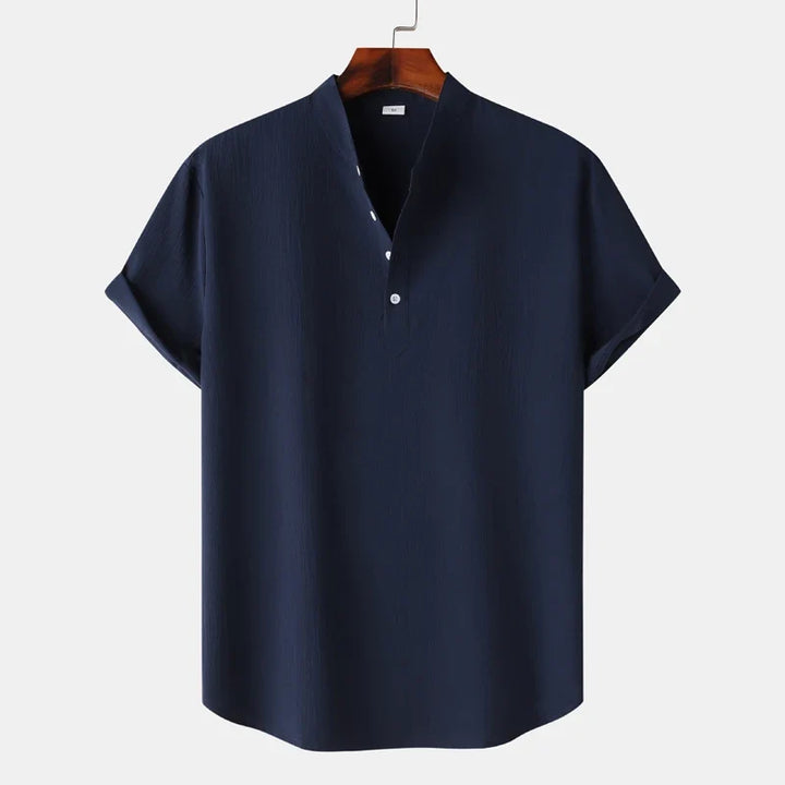 Detail of the soft fabric and button placket on a men's natural tone long sleeve henley shirt.
