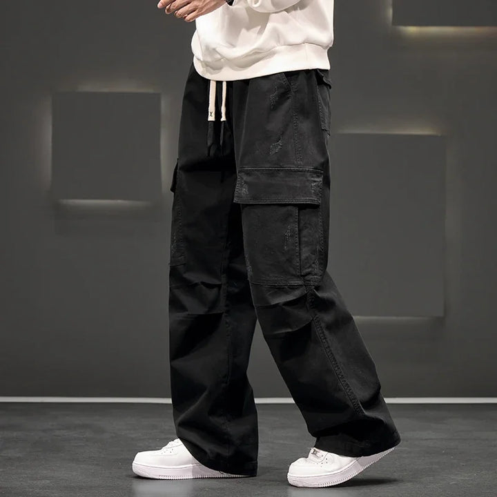Comfortable men's relaxed fit cargo pants with adjustable drawstring waist, perfect for outdoor utility.