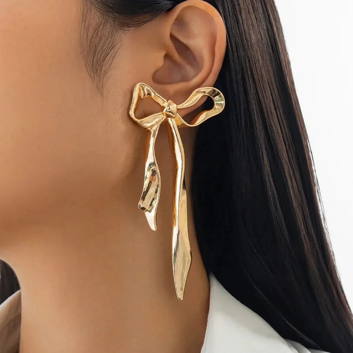Polished ribbon bow earrings, an elegant & delicate women's jewelry piece. Fashionable accessory, perfect for gifting.