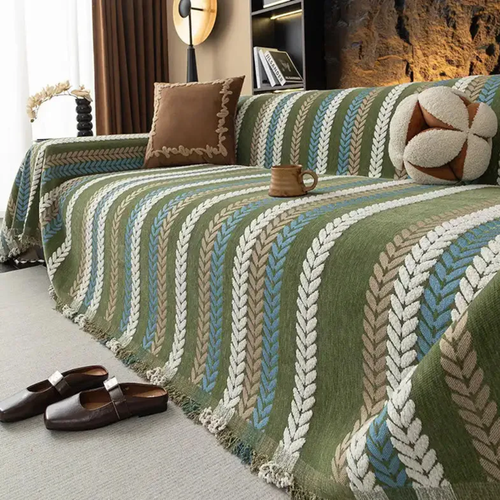 Chenille sofa cover with elegant leaf pattern, protecting a living room couch, easy care home decor.