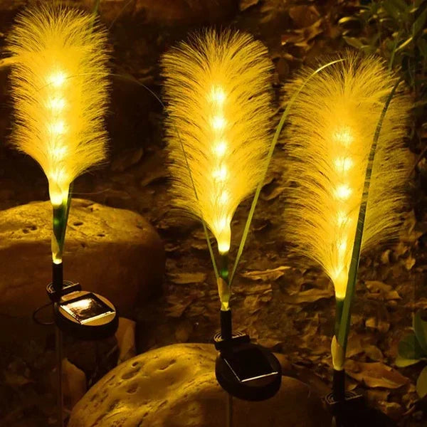 A set of durable outdoor reed lights illuminating a dark garden, perfect for decorative ambiance.