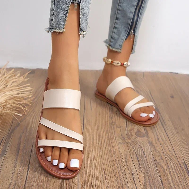 Soft cushioned women's flat sandals, practical slip-on cross-strap design for summer adventures.
