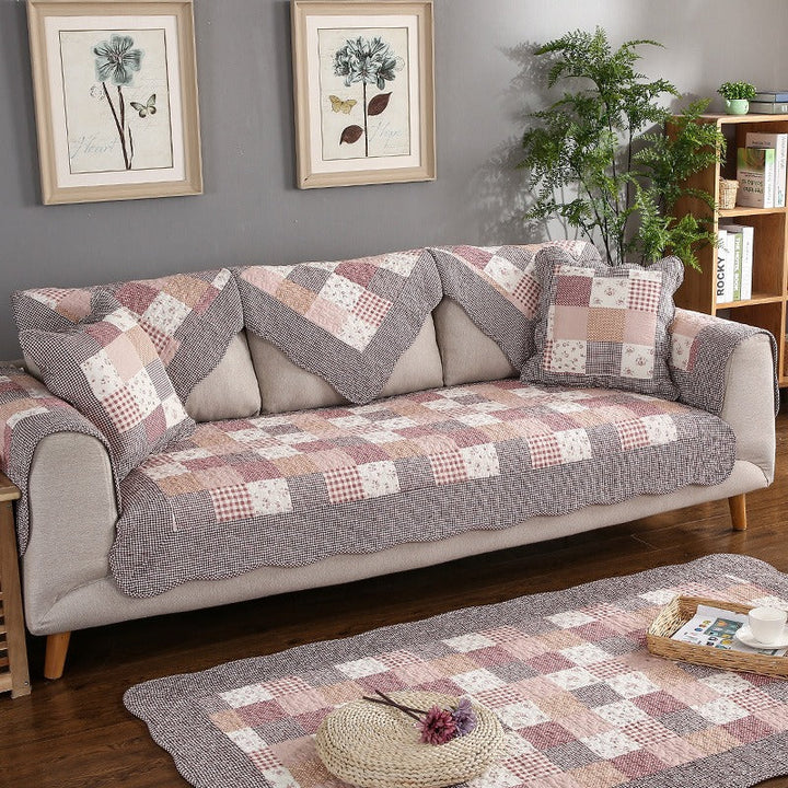 Quilted cotton sofa cover in a living room, protecting furniture. Washable, non-slip couch protector for home decor.