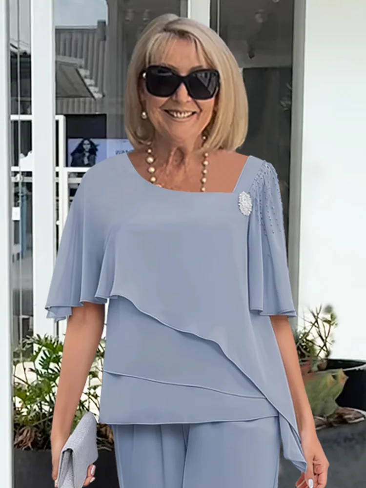 Chic light blue women's formal cape top and matching trousers, a sophisticated two-piece evening outfit.