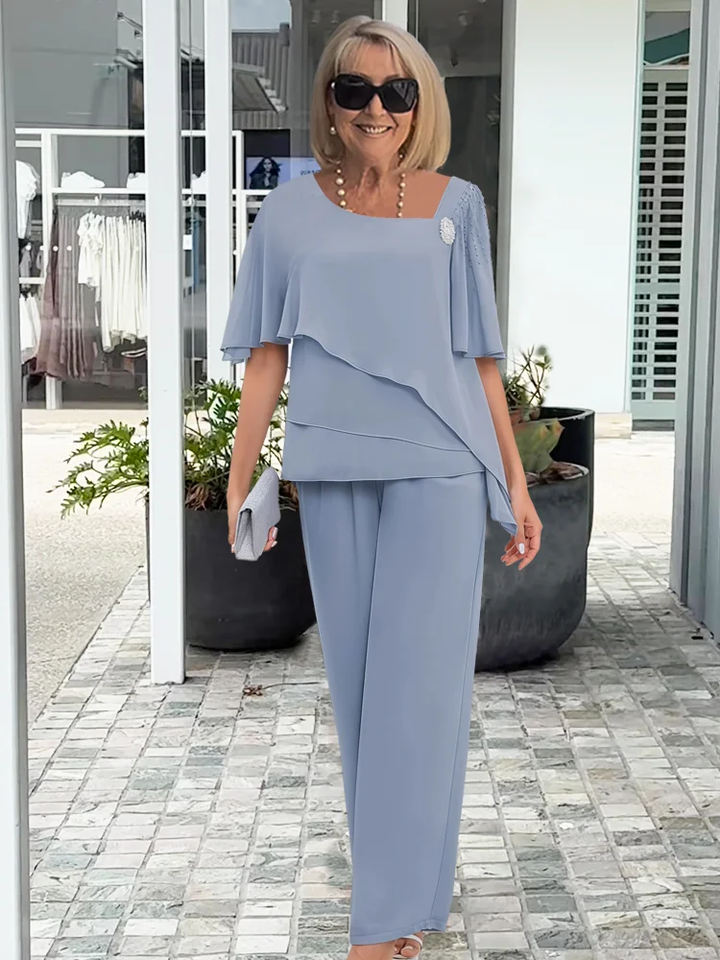 Coordinated women's tiered cape top & wide-leg trouser set with elegant pearl detail, ideal occasion wear.