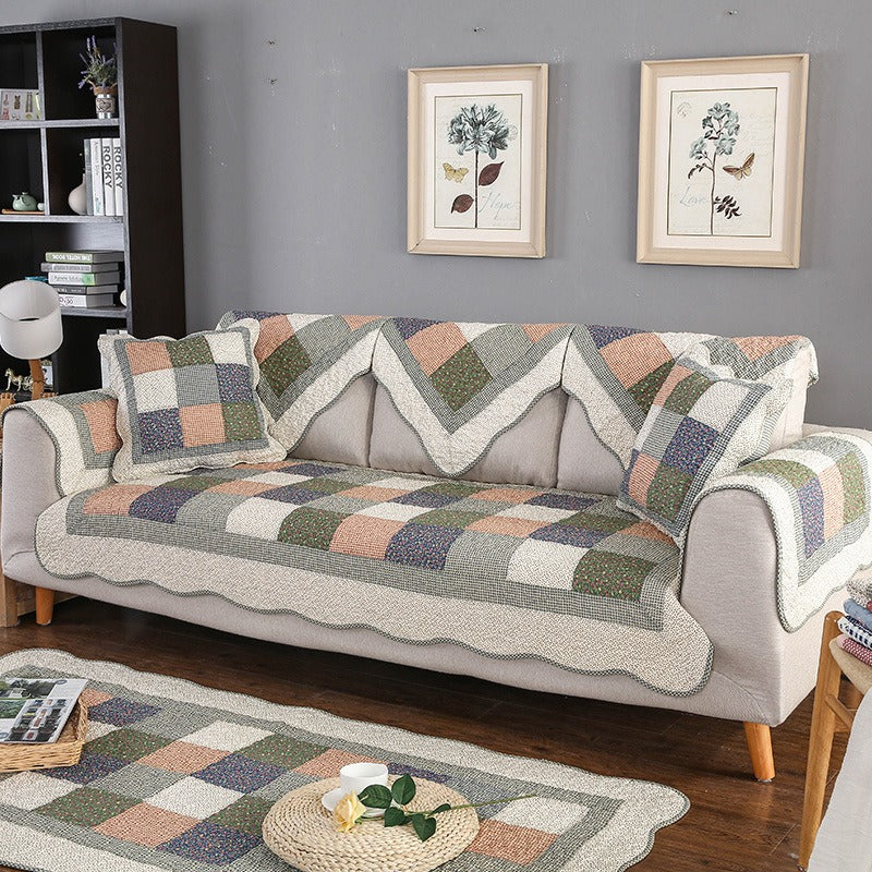 Living room scene with a cream quilted cotton sofa cover on a sectional, showing pet-friendly protection.