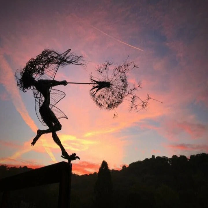 Outdoor metal art featuring a fairy dancing on a dandelion, ideal garden accent.