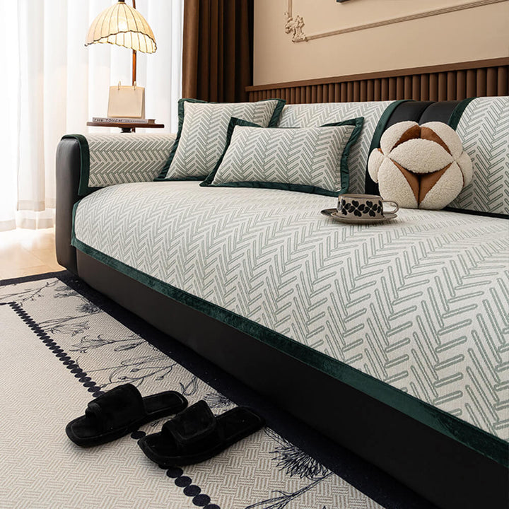 Grey herringbone chenille sofa protector draped on a couch, showing non-slip backing