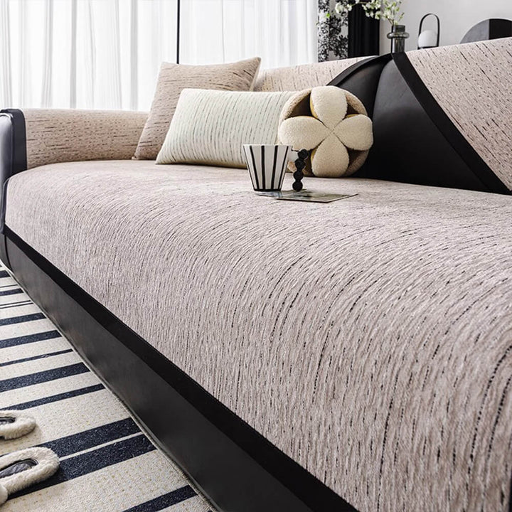 Stylish striped chenille sofa protector draped over a three-seater couch, decorative and functional
