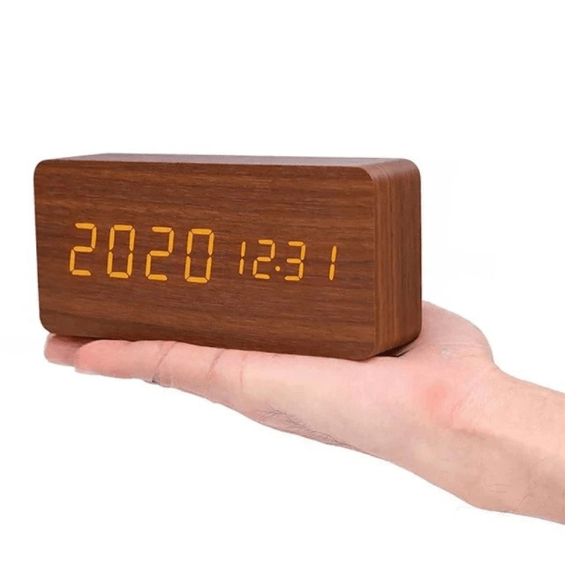 Compact digital alarm clock, wooden casing, voice-activated LED display for a modern bedroom.