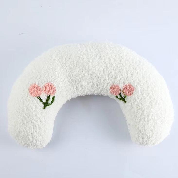 Dog relaxing in a grey U-shaped orthopedic bed, showing plush comfort and joint support.