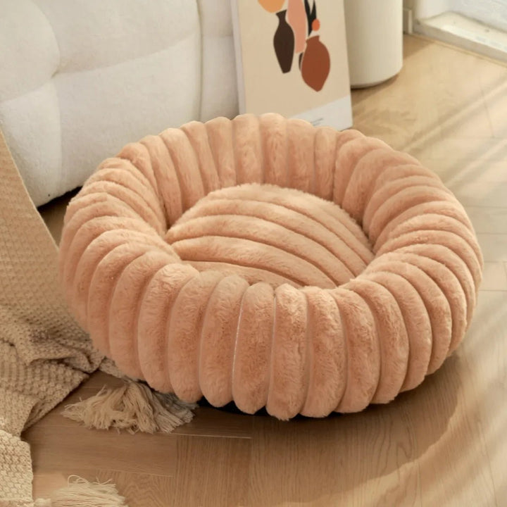 Washable donut dog bed with deep crevices, perfect for burrowing and calming anxious pets.