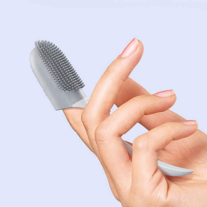 White pet finger toothbrush on a clean surface, emphasizing dog and cat dental care and freshness.