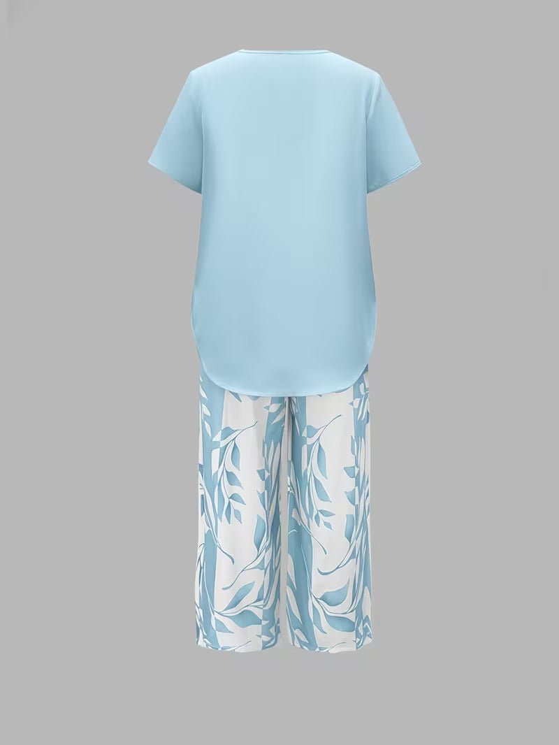 Woman walking in a stylish leaf print two-piece set: short sleeve top & cropped pants. Ideal summer fashion.
