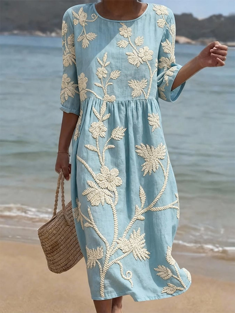 Women's embroidered midi dress with three-quarter sleeves, round neck, and delicate floral details.