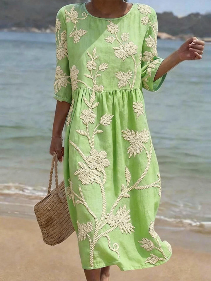 Stylish women's midi dress with intricate floral embroidery, three-quarter sleeves, ideal for spring fashion.