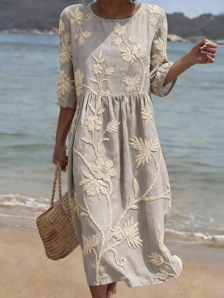 Women's three-quarter sleeve maxi dress featuring delicate floral embroidery and a graceful flowing design.