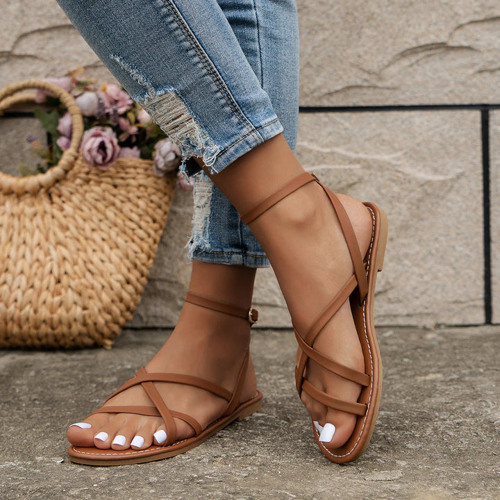 Stylish women's flat sandals: open-toe design, secure ankle strap. Perfect comfortable summer shoes.