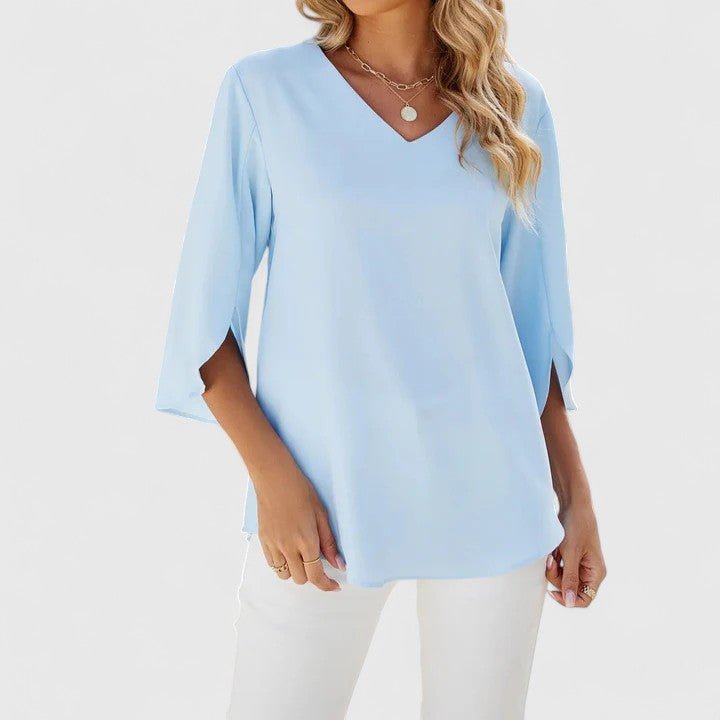 Relaxed fit women's blouse: V-neck, ruffles, and split sleeves for a modern, feminine look.